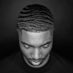 Portrait d'un homme noir qui présente ses 360 waves